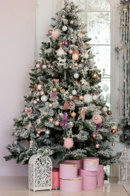 grande e linda árvore de Natal decorada em cores rosa e caixas rosa com presentes embaixo