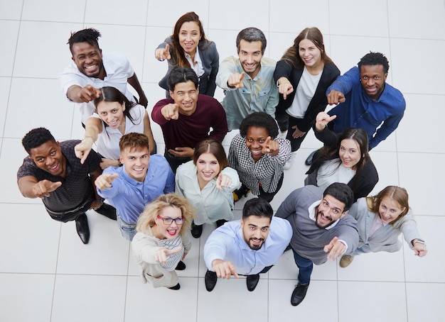 Grande equipe de jovens apontando para algum lugar acima