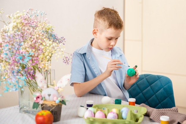 Grande família feliz se preparando para a páscoa menino bonito pintando ovo atividade doméstica conceito de unidade e amor