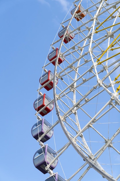 Grande ferris com roda de cabines contra parte do céu azul profundo da roda gigante no parque de diversões