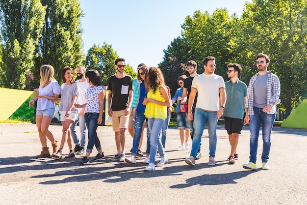 Grande grupo de amigos caminhando juntos no parque