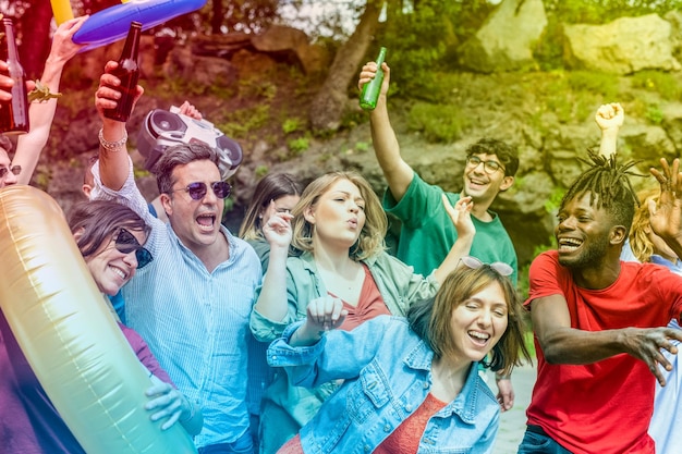 Grande grupo de amigos de diferentes idades, culturas e etnias se divertindo em uma festa de aniversário dançando celebração entre amigos e familiares efeitos de cores digitais