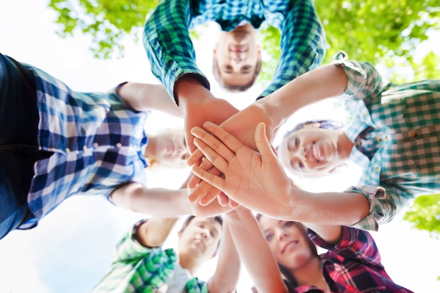 Grande grupo de amigos sorridentes, ficando juntos e olhando para a câmera, isolada em um fundo azul