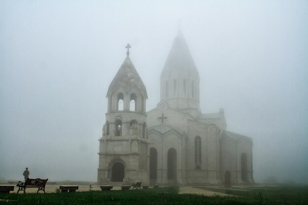 Grande igreja pedregosa cercada por vegetação em shushi artsakh