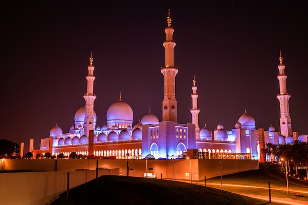 Grande Mesquita em Abu Dhabi à noite. Vista panorâmica do exterior de Sheikh Zayed Mosquein Emirados Árabes Unidos com relâmpago épico.