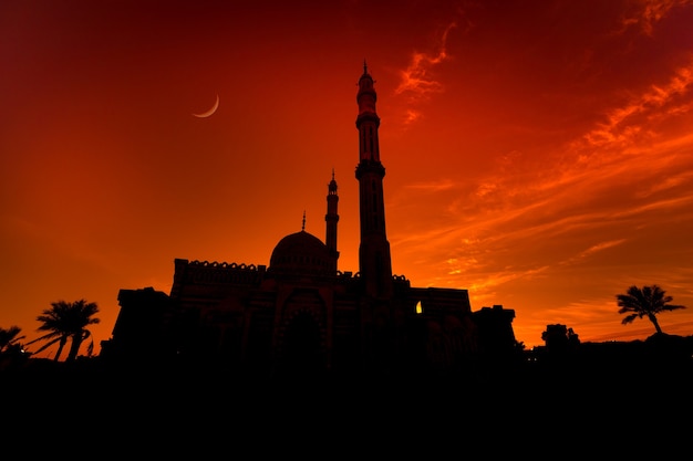 Grande mesquita islâmica bonita no céu do pôr do sol