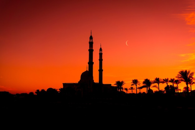 Grande mesquita islâmica bonita no céu do pôr do sol