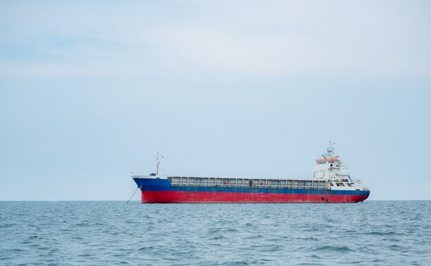 Grande navio de carga no oceano e na paisagem do céu azulBarquinho de carga na economia logística do mar