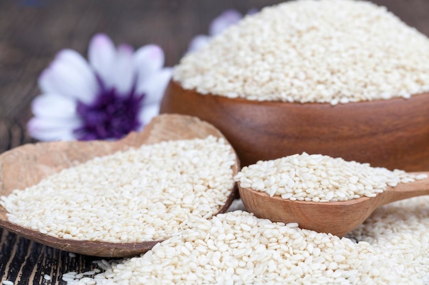 Grande número de sementes de gergelim usadas na culinária e preparação de alimentos, sementes de gergelim brancas em uma mesa de madeira