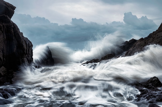 Grande onda batendo nas rochas da costa em tempestade no mar tropical