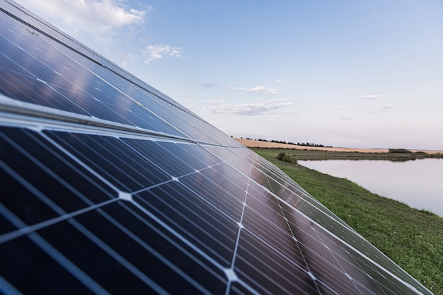 Grande painel solar perto do lago com pássaros, energia renovável eco