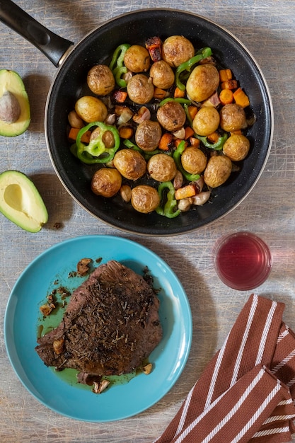 Grande pedaço frito de carne de presunto em panela com legumes especiarias almoço pedaço frito de carne e batatas