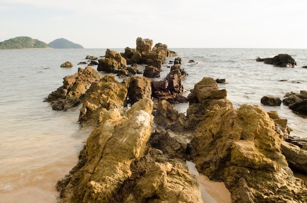 Foto grande pedra no mar, local tropical