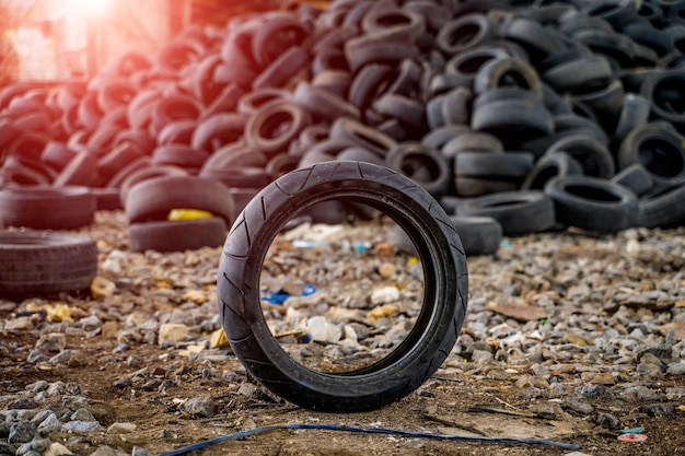 Grande pilha de pneus de automóveis na planta quebrada Um pneu na vista frontal Pneus de borracha pretos dentro do antigo prédio enorme vazio