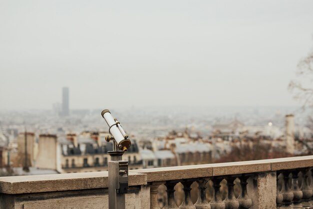 Grande plano do binóculo com vista sobre o horizonte urbano da cidade de Paris