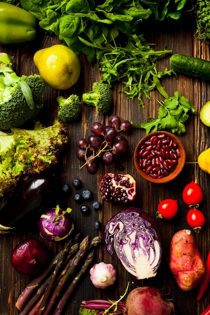 Foto grande quantidade de verduras e legumes em um fundo escuro de madeira. conceito de comida antienvelhecimento