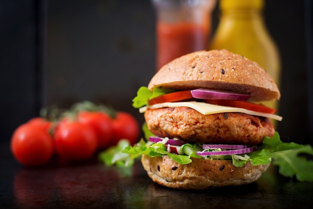 Grande sanduíche - hambúrguer com hambúrguer de frango suculento, queijo, tomate e cebola vermelha