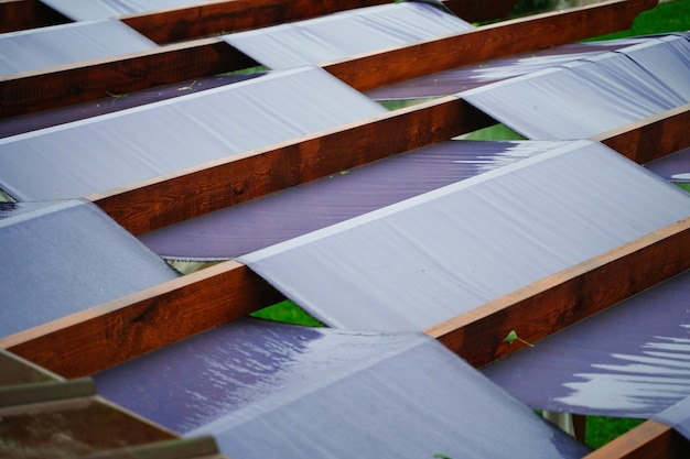 Grande terraço com painéis de tecido e vigas de madeira para proteção solar
