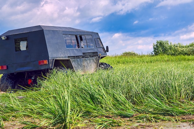 Grande transportador offroad poderoso no fundo de um céu azul com nuvens