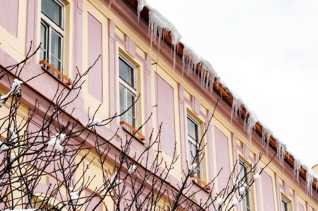 grandes y afilados helados colgando desde el techo en la fachada del edificio peligroso derretimiento de hielo en el techo