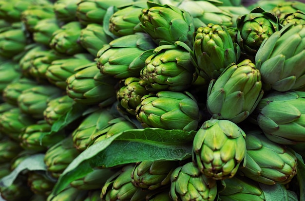 Grandes alcachofas orgánicas maduras a la venta en el mercado local.