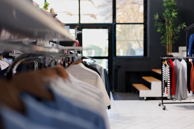 Grandes almacenes de ropa vacíos en el centro comercial, nueva colección de moda en el estante. Ropa de moda en perchas y accesorios, boutique moderna con mercadería a la venta para los clientes