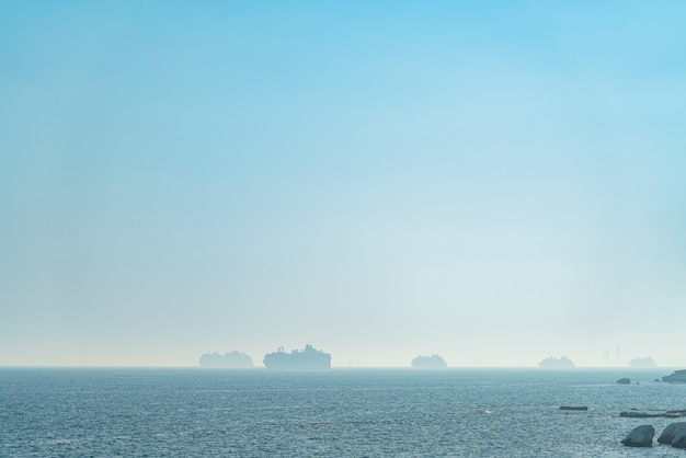 Grandes buques portacontenedores y cruceros en neblina matutina cerca de Limassol, Chipre.