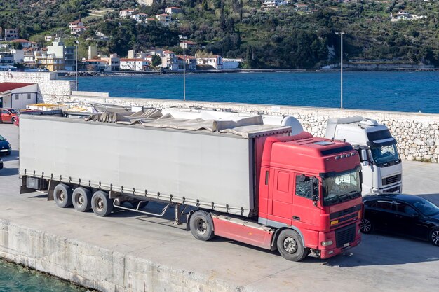 Grandes camiones en el puerto están esperando para ser cargados en el barco Grecia