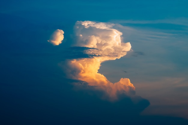 Foto grandes cúmulos blancos al atardecer y cielo azul.