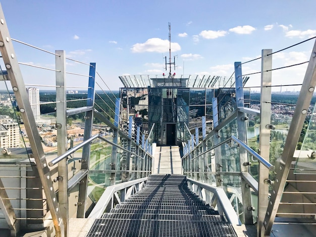 Grandes escaleras de metal cromado brillante con barandillas en el techo de un rascacielos de cristal un edificio alto