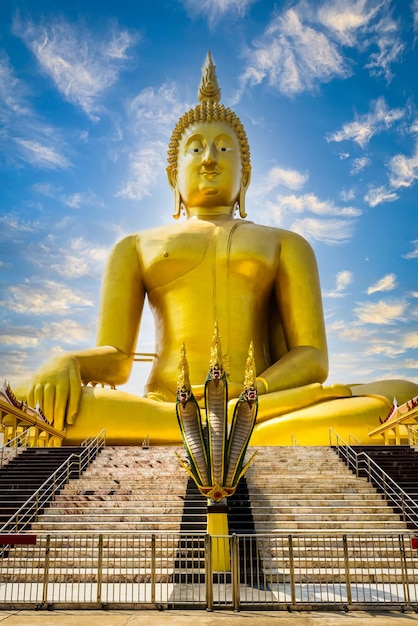 Grandes estátuas de Buda dourado com serpente na frente em ang tanga Tailândia xA