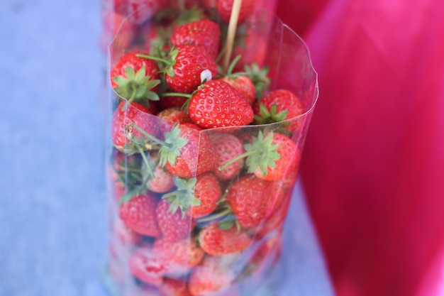 Las grandes fresas rojas brillantes en una bolsa de plástico se ven apetitosas