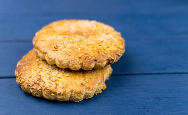 Grandes galletas redondas espolvoreadas con nueces sobre un fondo de madera azul