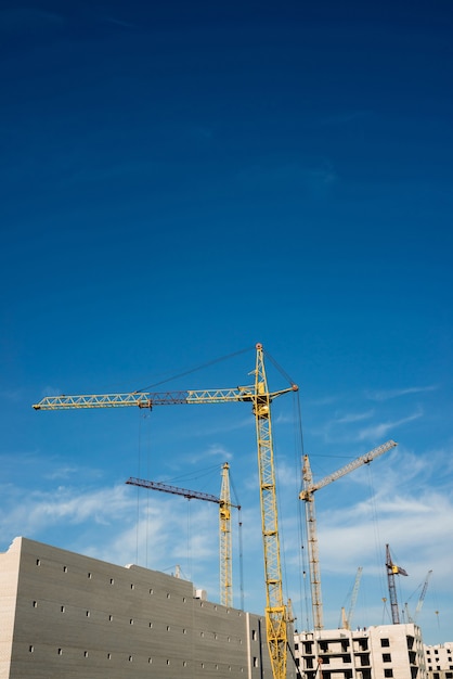 Grandes grúas torre sobre edificios en construcción