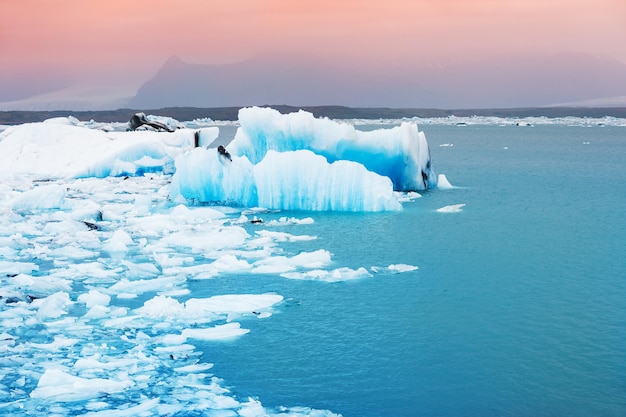 Grandes icebergs azules en la laguna glaciar de Jokulsarlon, en el sur de Islandia. Hermoso paisaje al atardecer