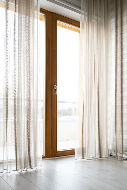 Grandes janelas com cortinas transparentes na sala de estar