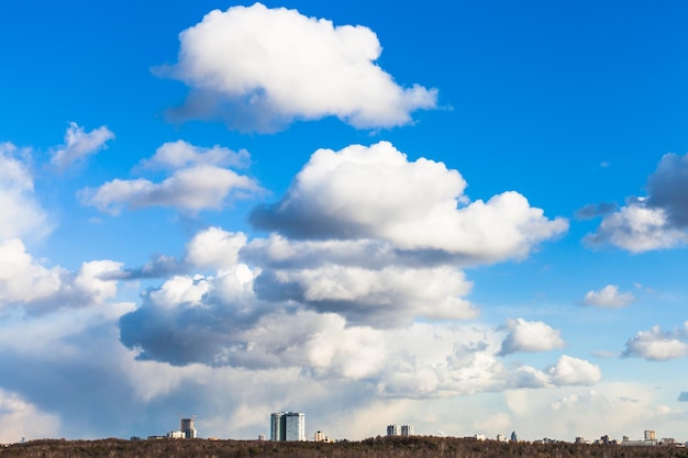 Grandes nubes en el cielo azul sobre casas urbanas