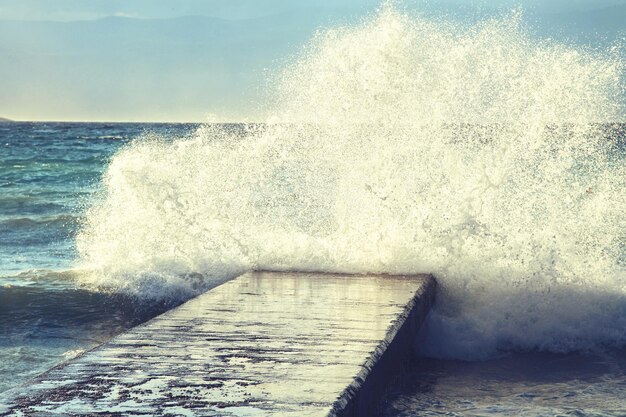 Grandes ondas esmagando no cais de pedra em tempo tempestuoso