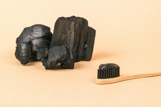 Grandes pedaços de carvão e uma escova com pasta de dentes Clareamento dos dentes e produtos para cuidados dentários