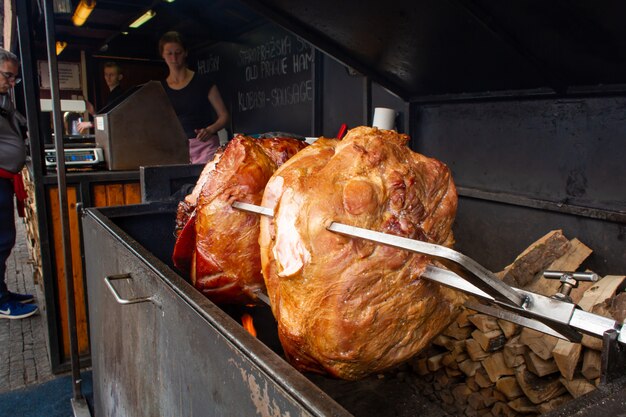 Grandes pedaços suculentos de carne são grelhados. comida de rua na praça no centro da cidade velha