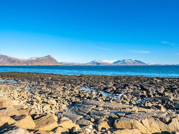 Grandes pedras na península de Akranes perto dos faróis sob o céu azul Islândia