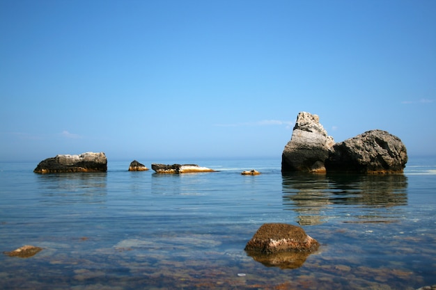 Grandes piedras en el agua junto al mar