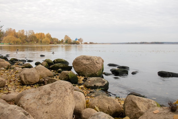 Grandes piedras en la orilla del lago en otoño