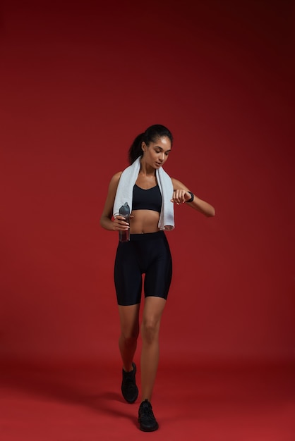 Grandes resultados de longitud completa de mujeres afroamericanas seguras en ropa deportiva con toalla
