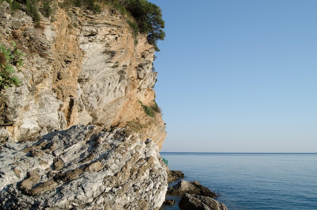 Grandes rocas son lavadas por agua limpia y clara del mar Adriático en un día caluroso