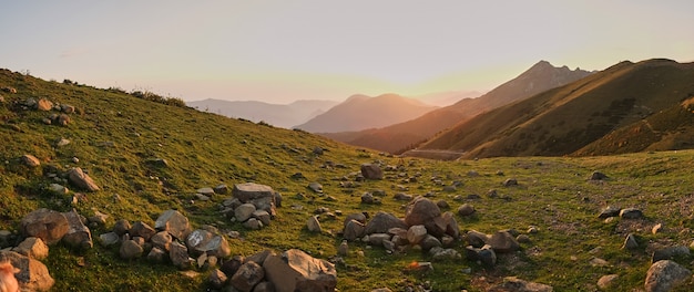 Foto grandes rochas de quartzo em um prado de montanha. pôr do sol nas montanhas.