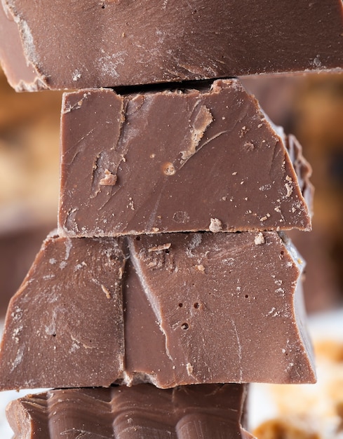 Grandes trozos de chocolate con leche sobre la mesa. galletas de trigo y chocolate rotas con gotas de chocolate