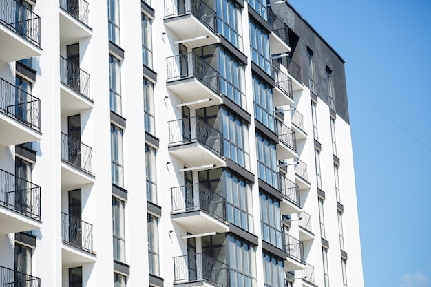 Grandes ventanas panorámicas de plástico. Fachada de un nuevo edificio en la casa durante las obras de construcción. Edificio de varios pisos durante la construcción