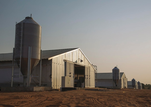 Un granero con un silo al fondo.