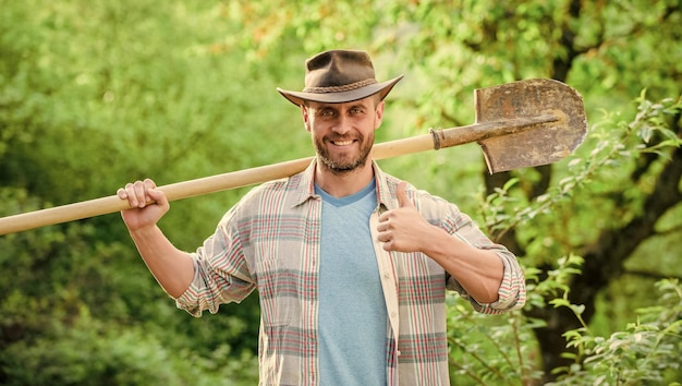 Foto granja ecológica cosecha granjero sexy sostener pala agricultura y cultivo agrícola equipo de jardín feliz día de la tierra vida ecológica rancho musculoso hombre con sombrero de vaquero jardinero en el trabajo